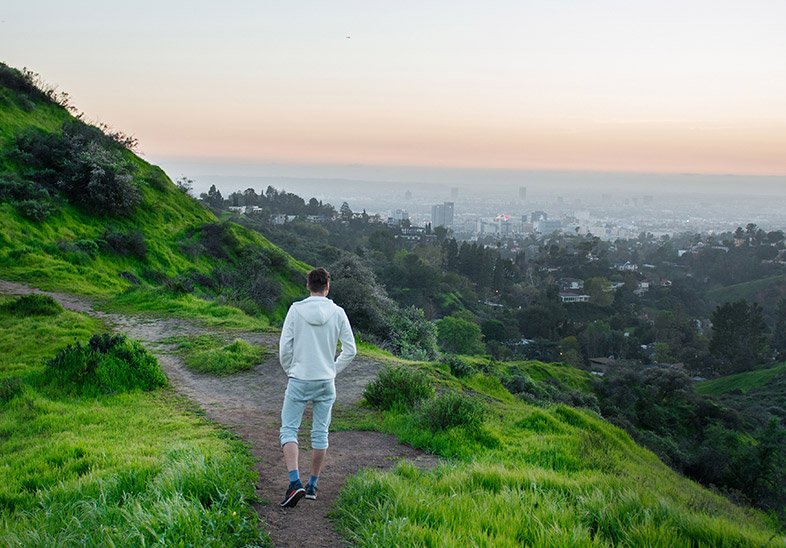 Man hiking a green trail Los Angeles